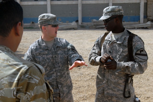 BAGHDAD - Staff Sgt. Joseph Willett (left), a section sergeant from Evansville, Ind., talks with Sgt. Steven Barner, a tank gunner from Greenwood, Miss., during an Iraqi Army training Academy. The Soldiers have been together most of their Army...