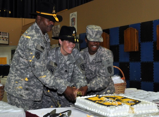 Lt. Col. Paula Lodi, the commander of the 15th Special Troops Battalion, 15th Sustainment Brigade and Franklin, Mass., native, chops a "Wagonmaster" cake in two with a cavalry saber with the oldest Wagonmaster Master Sgt. Stanley Dyches, the brigade ...