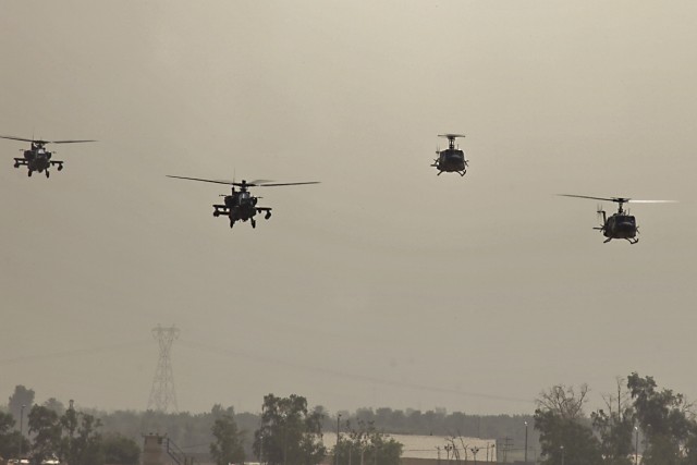 CAMP TAJI, Iraq-Two Iraqi UH-1 Hueys (right) from 2nd Squadron, Iraqi Air Force, and two U.S. AH-64D Apache attack helicopters (left), from 1st Battalion, 227th Aviation Regiment, 1st Air Cavalry Brigade, 1st Cavalry Division, return to Camp Taji, Ir...