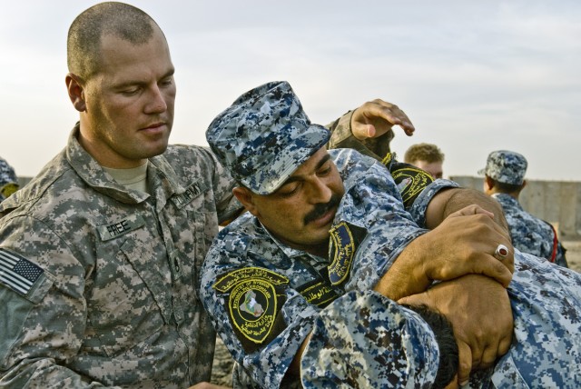 BAGHDAD - Staff Sgt. David Free (left), from Hull, Ga., inspects an Iraqi Federal Policeman's arm hold during combatives training at Joint Security Station Istaqlal, here, Oct. 20. "The main thing is defensive tactics just to help these guys out if t...