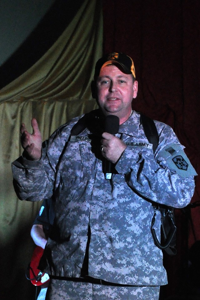 Col. Larry Phelps, the commander of the 15th Sustainment Brigade, sings Jimmy Buffett's "Margaritaville" during a performance by the Army Materiel Command Band, Raw Material, Oct. 17 at the Morale, Welfare and Recreation theater at Contingency Operat...