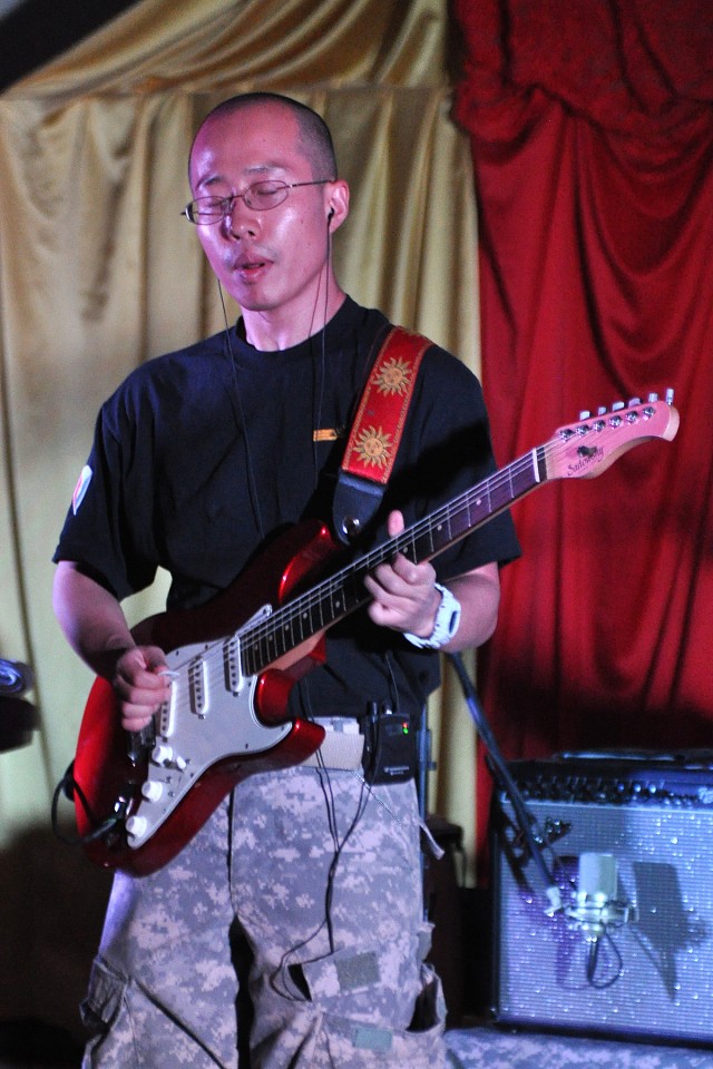 Spc. Dong Lee, with the Army Material Command Band, Raw Material, rocks through the guitar solo of "Hotel California," during the band's performance Oct. 17at the Morale, Welfare and Recreation theater at Contingency Operating Location, Iraq. ...