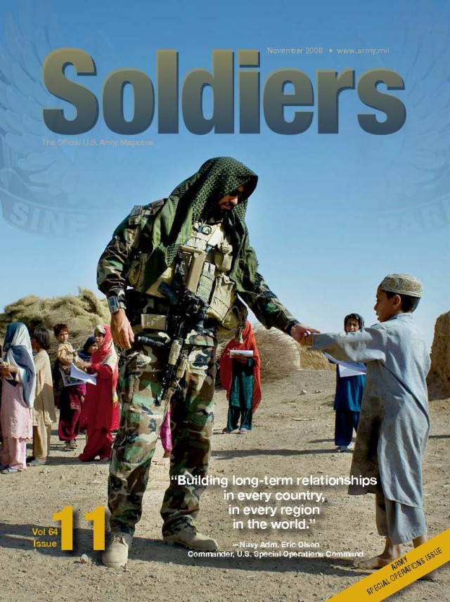 A Special Forces Soldier with A Co., 1st Bn., 7th Special Forces Group gives an Afghan boy a coloring book in Kandahar Province, during a meeting with local leaders, Sept. 12, 2008. The SF team and Afghan commandos met with religious leaders to...