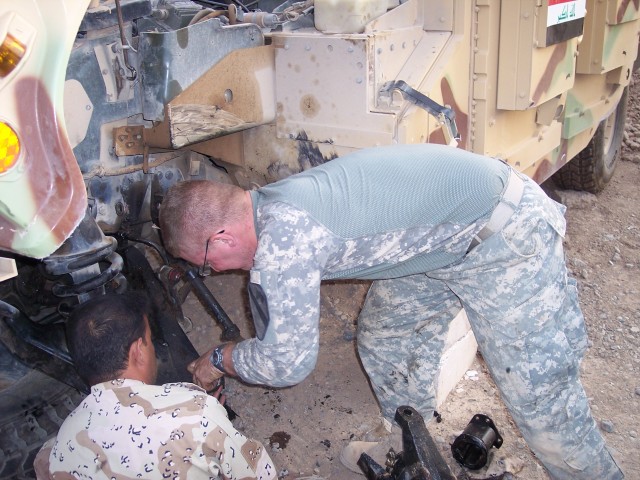 A mechanic from 1st Battalion, 8th Cavalry Regiment, 2nd Brigade Combat Team, 1st Cavalry Division, instructs an Iraqi Army mechanic on maintenance of a humvees, Oct 12. U.S. Army mechanics have been instructing IA and Iraqi Police mechanics on...