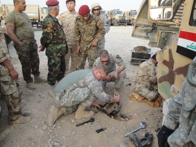 Mechanics from 1st Battalion, 8th Cavalry Regiment, 2nd Brigade Combat Team, 1st Cavalry Division, show Iraqi Army mechanics proper maintenance of a humvee, Oct. 12. U.S. Army mechanics have been instructing IA and Iraqi Police mechanics on how to...