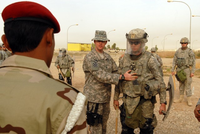 Sgt. Chris Murdoch (left), a Niantic, Conn. native and military police officer with the 218th Military Police Company from Fort Campbell, Ky., instructs Iraqi military police from the 12th Iraqi Army Division, on the different formations and...