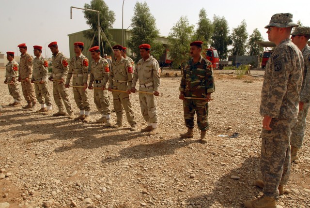 Sgt. Chris Murdoch (right), a Niantic, Conn. native and military police officer with the 218th Military Police Company from Fort Campbell, Ky., instructs Iraqi military police from the 12th Iraqi Army Division, on using a baton and moving toward a...