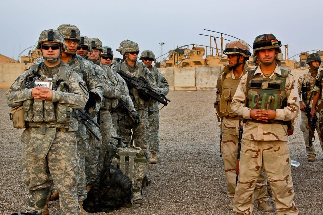 CAMP TAJI, Iraq-Soldiers from 1st Battalion, 5th Cavalry Regiment, 1st Brigade Combat Team, 1st Cavalry Division, and Iraqi Army Soldiers from 3rd Company, 2nd Battalion, 37 IA Brigade, line up to load onto aircraft for a joint air assault mission, O...