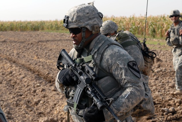 TAJI, Iraq- Killeen, Texas native, Spc. Timothy Tanner, an armor crewman attached to the 1st Battalion, 82nd Field Artillery Regiment, 1st Brigade Combat Team, 1st Cavalry Division, patrols with his squad through a field during a combined air...