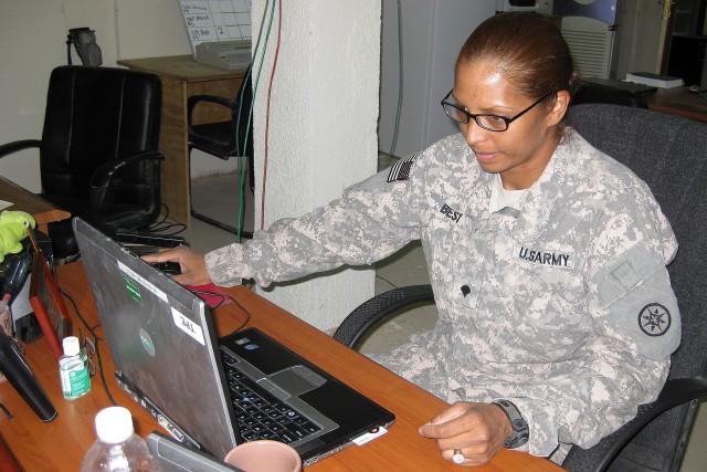 Spc. Yochanah Best, a paralegal specialist with the 395th Combat Sustainment Support Battalion, 15th Sustainment Brigade, works on her computer Oct. 23 at the Soldier Services Center here. Best became a U.S. citizen last year and now helps other Sold...