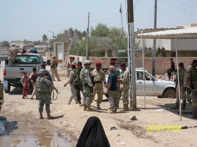 Capt. Brent Harrington speaks with local Iraqis and Iraqi soldiers in Majar al Kabir area of southern Iraq during a patrol in 2008. Harrington was presented a Joint Commander’s Commendation from the British Army at the 1st Cavalry Division...