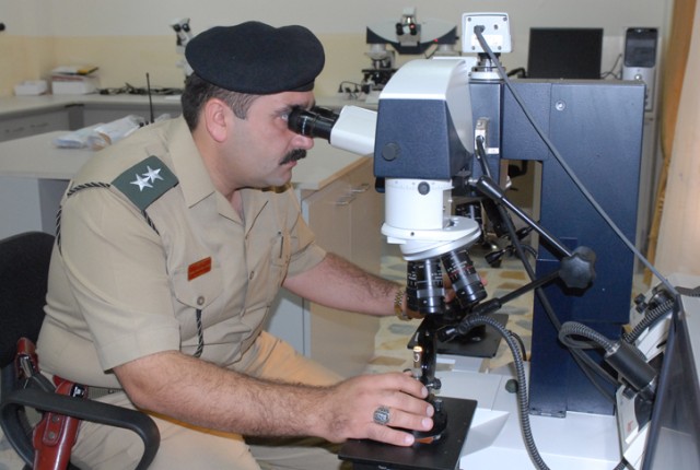 First Lieutenant Rawand Jawad, an investigative officer at the Criminal Forensics Lab in Erbil, shows how to use a new piece of equipment in the ballistics testing lab during a tour of the facility for a group of 18 judges and lawyers Oct. 27....