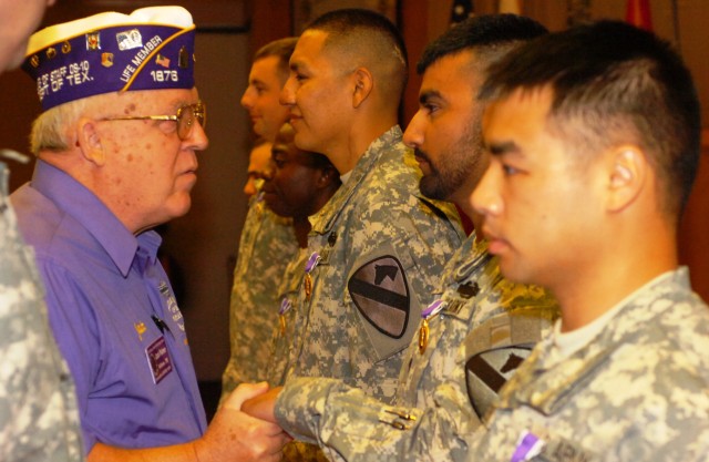 Jack Palmer, Commander of the Military Order of the Purple Heart, shakes hands with Spc. Kevin Garcia, from Inverness, Fla., assigned to Headquarters and Headquarters Company, 1st Battalion, 5th Cavalry Regiment, 2nd Brigade Combat Team, 1st Cavalry ...