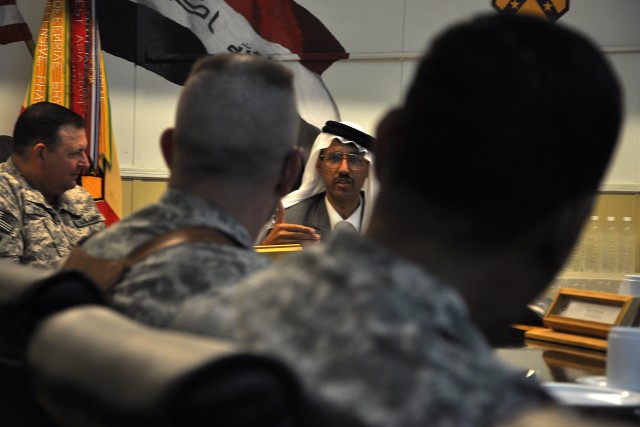 CONTINGENCY OPERATING LOCATION Q-WEST, Iraq - Doctor Mohammad, a local doctor and friend of coalition forces, explains his life's story to members of the 15th Sustainment Brigade staff during a dinner at the brigade's headquarters here Oct. 24....