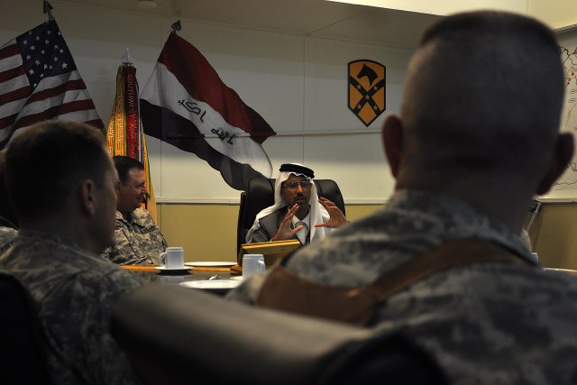 CONTINGENCY OPERATING LOCATION Q-WEST, Iraq - Doctor Mohammad, a local doctor and friend of coalition forces, explains his life's story to members of the 15th Sustainment Brigade staff during a dinner at the brigade's headquarters here Oct. 24....