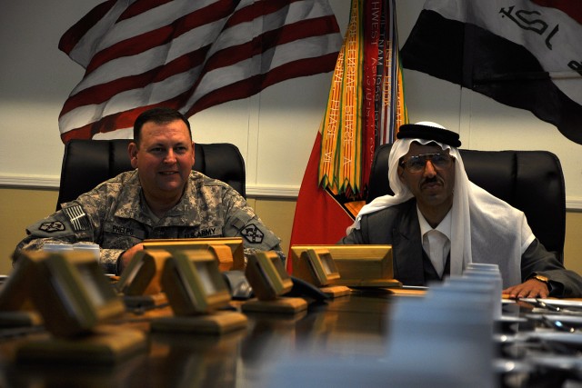 CONTINGENCY OPERATING LOCATION Q-WEST, Iraq - Col. Larry Phelps, the commander of the 15th Sustainment Brigade, and Doctor Mohammad, a local doctor and friend of coalition forces, listen as member of the brigade staff introduce themselves during...