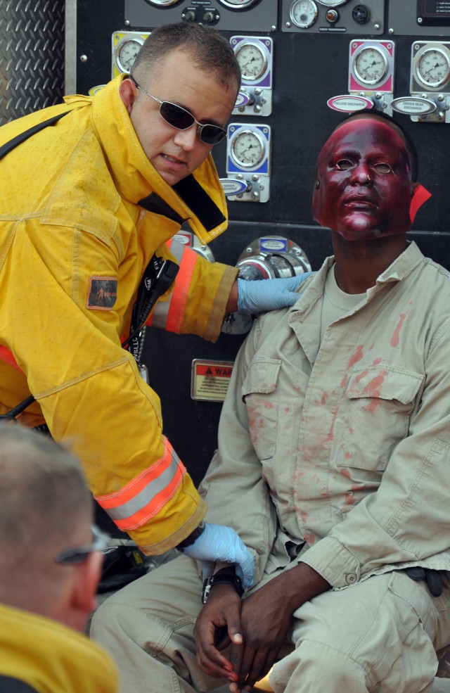 James Snyder, Q-West firefighter and San Antonio native, checks the pulse of role player Sgt. Joseph Page, an A Company 106th Support Battalion supply specialist and Hattiesburg, Miss. native as part of a mass casualty exercise here Oct. 28. (U.S. Ar...