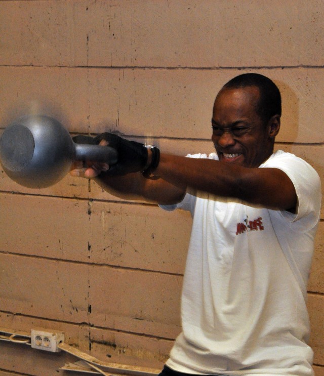 Derrick Milligan, a radio frequency identification field service engineer for 15th Sustainment Brigade, swings a kettle bell during part of a CrossFit training session in the new Headquarters and Headquarters, 15th Special Troops Battalion, 15th...