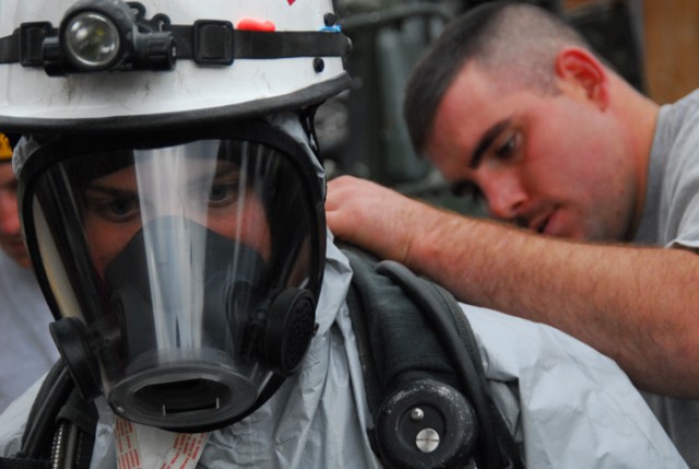 LORTON, Va -- U.S. Army Sgt. Matt Arnold of the 911th Technical Rescue Engineer Company tightens up teammate Sgt. Hattie Lynch's Self-Contained Breathing Apparatus (SCBA) as they prepare for the possibility of entering a contaminated environment...