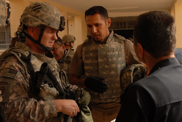 Brigadier General Patrick Donahue, the MND-N deputy commanding general for Maneuver, speaks through an interpreter to Col. Adnan Hameed Salaa, the police chief of the Adallah IP Station, during a humanitarian-aid delivery in the Adallah District of K...