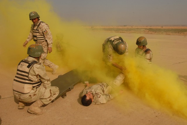 Iraqi Army Soldiers with the 12th MTR, 12th IAD, perform life-saving skills inside a fog of brightly colored smoke during a competition at K-1 Military Base in Kirkuk, Nov. 1. This competition was an opportunity for the Soldiers to test not only...