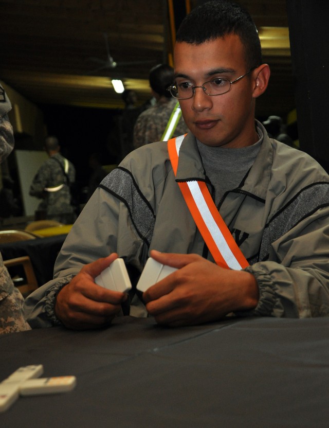 Sgt. Joel Sauceda, a 15th Special Troops Battalion, 15th Sustainment Brigade, ammo specialist and Anaheim, Calif., native, plans his next move during a dominoes tournament at the battalion's headquarters here Oct. 30 as part of a unit movie night. So...
