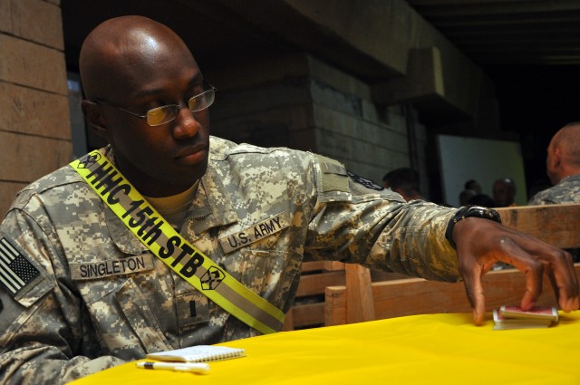 First Lt. Josh Singleton, a Buford, S.C., native and 15th Special Troops Battalion, 15th Sustainment Brigade, medical operations officer in charge, cuts a deck of cards at the 15th Special Troops Battalion, 15th Sus. Bde., headquarters here Oct. 30 a...