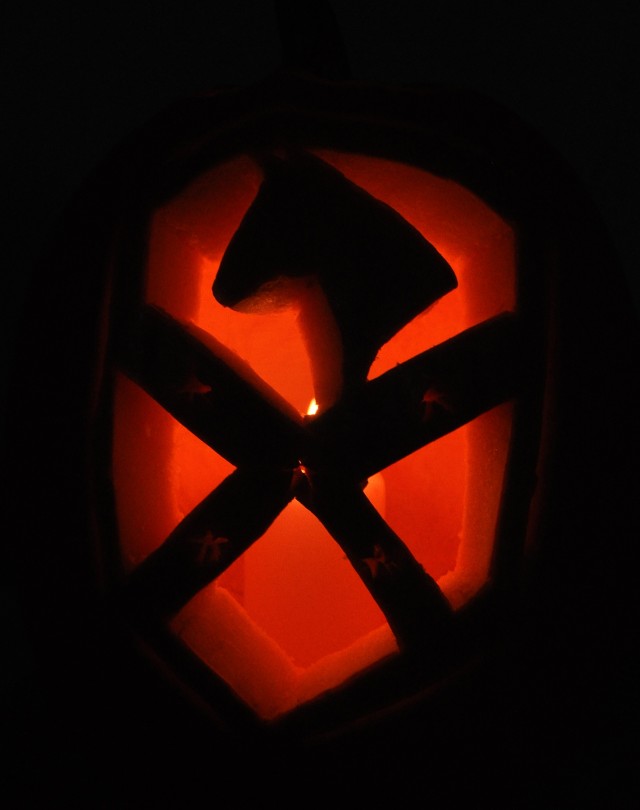 A jack-o-lantern carved to look like the 15th Sustainment Brigade patch sits on a table at the 15th Special Troops Battalion, 15th Sus. Bde., headquarters here Oct. 30 as part of a unit movie night. Soldiers enjoyed barbecue, a movie, and dominoes an...