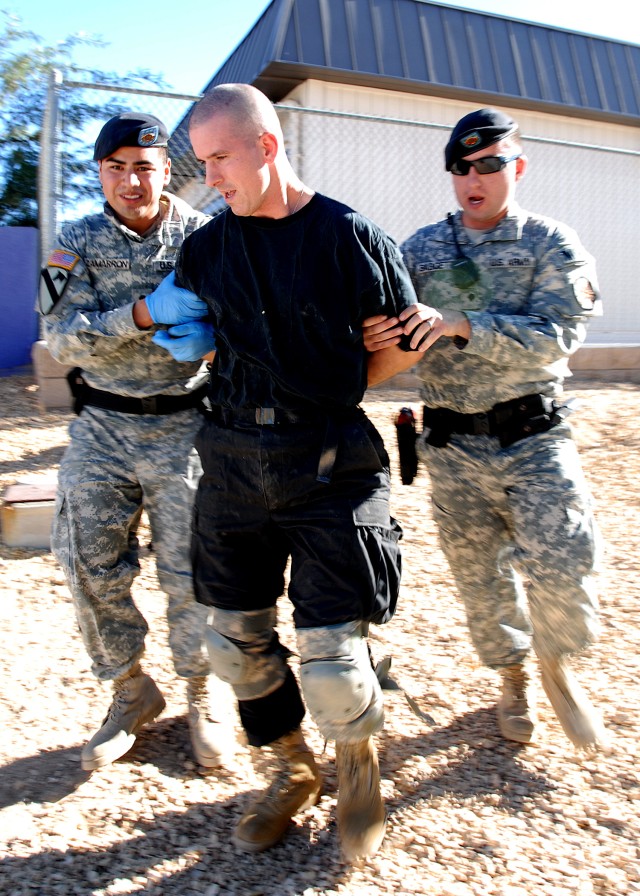 A "suspect" is apprehended by Spc. Josuel Zamarron and Spc. James Baggett, both military police officers with the Fort Irwin U.S. Army Garrison Military Police Company, during a training event Oct. 25. The training scenario involved a suspects who we...