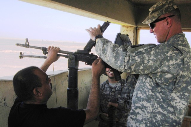 CONTINGENCY OPERATING LOCATION Q-WEST, Iraq - Capt. James Clark, a Madison, Miss., native and commander of A Company, 2nd Battalion, 198th Combined Arms out of Hernando, Miss., performs a function check on a PKM 7.62 calibur machine gun during an ins...