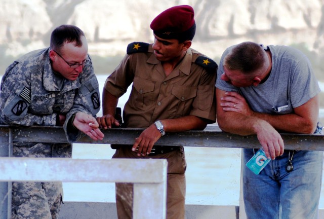 CONTINGENCY OPERATING LOCATION Q-WEST, Iraq - Sgt. Joshua Haycraft (left) Brandon, Miss., native and member of Headquarters and Headquarters Company, 2nd Battalion, 198th Combined Arms out of Senatobia, Miss., briefs 2nd Lt. Hassan Kalid of 1st Compa...
