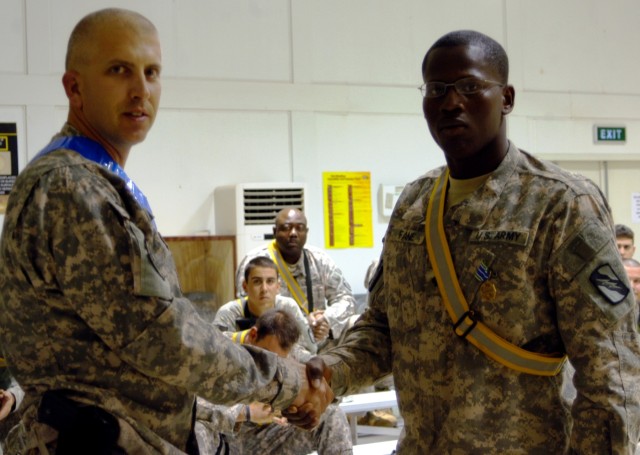CONTINGENCY OPERATING LOCATION Q-WEST, Iraq - Lt. Col. Kerry Goodman (left), a Hattiesburg, Miss., native and commander of 2nd Battalion, 198th Combined Arms headquartered in Senatobia, Miss., awards an Army Achievement Medal to Spc. Corderal Fane, a...