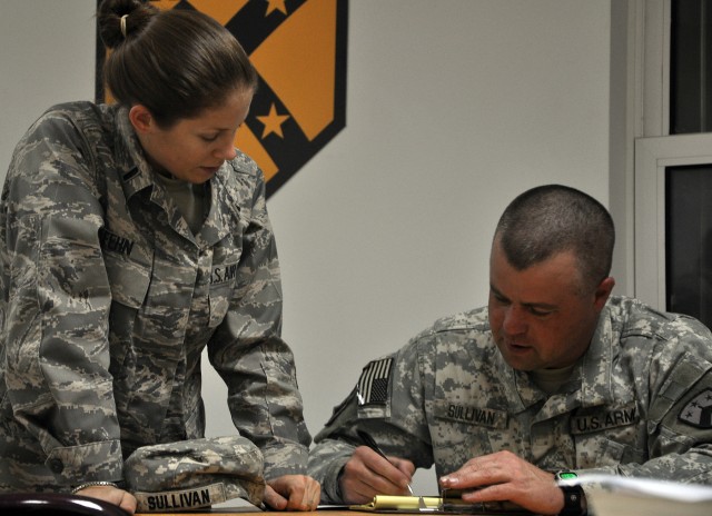 Airforce 1st Lt. Augusta Fehn, defense contract manager and Las Vegas native, helps a Functional Academic Skills Training student with a math problem at the newly reopened education center here, Nov. 5. (U.S. Army photo by Sgt. Matthew C. Cooley,...