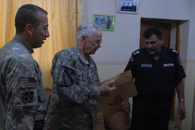 J. Tucker, a law enforcement professional working with the U.S. Army, shares evidence with Lt. Col. Fitaah, the police chief of a station in Hawijah, Iraq, during a meeting at Fitaah's station Nov. 5. Both the U.S Army and the Iraqi Police regular...