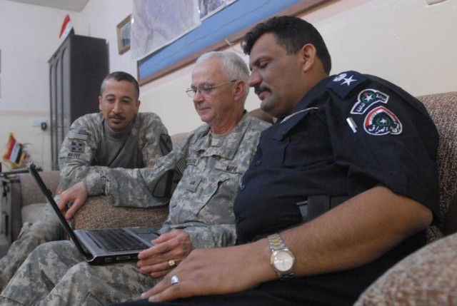 J. Tucker, a law enforcement professional working with the U.S. Army, and Lt. Col. Fitaah, the police chief of a station in Hawijah, Iraq, watch surveillance footage together during a meeting at Fitaah's station Nov. 5. The surveillance footage...