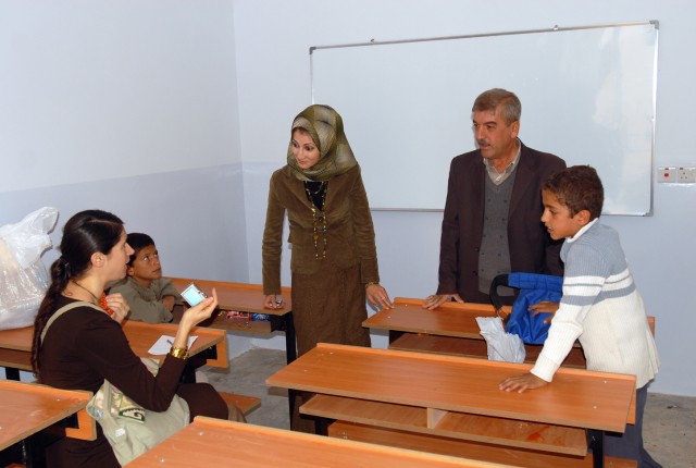 Kirkuk's Provincial Reconstruction Team Public Diplomacy Officer Stacy Barrios (seated left) speaks with teachers and students during the opening of the new Chemin Primary School in Kirkuk province, Iraq, Nov. 3. The project was a combined initiative...