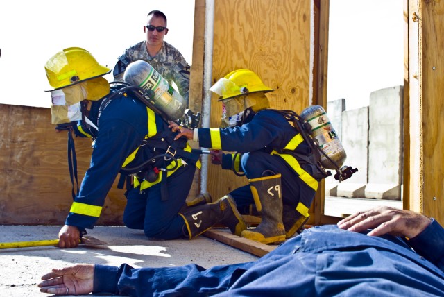 BAGHDAD - Iraqi firefighters from the 29th Center for Defense are blindfolded before trying to enter a mock building to save a fire victim as Lisbon, Maine native, Cpl. John Curtis, a combat medic and former firefighter, watches closely during a join...