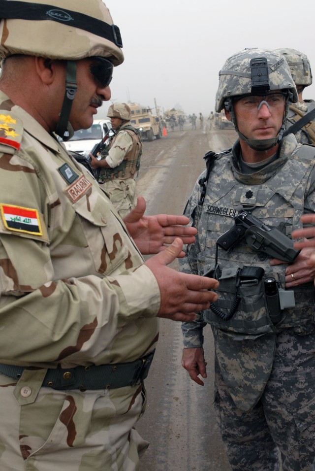 TAJI, Iraq- Iraqi Staff Brig. Gen. Munim Abd al Sattar (left), commander of the 37th Brigade, 9th Iraqi Division,  and Ozark, Ala. native, Lt. Col. Eric Schwegler, commander of the 1st Battalion, 82nd Field Artillery Regiment, 1st Brigade Combat Team...