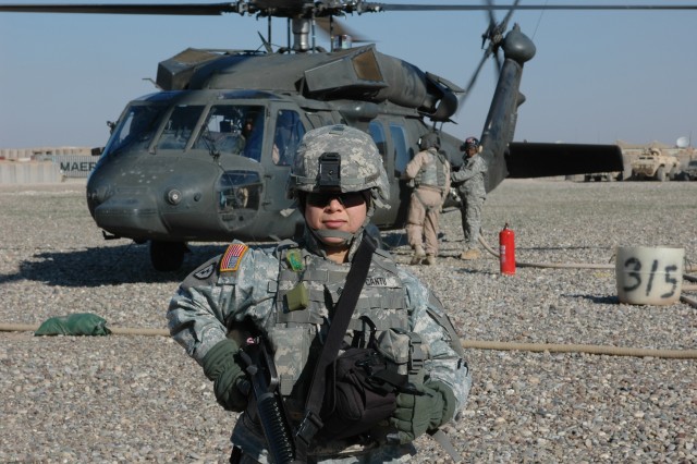 Staff Sgt. Rosy Cueva, automations noncommissioned officer, 25th Combat Aviation Brigade, gets ready to fly with several other members of her unit to visit remote sites scattered throughout northern Iraq ,Christmas Day 2006. Cueva helped deliver holi...