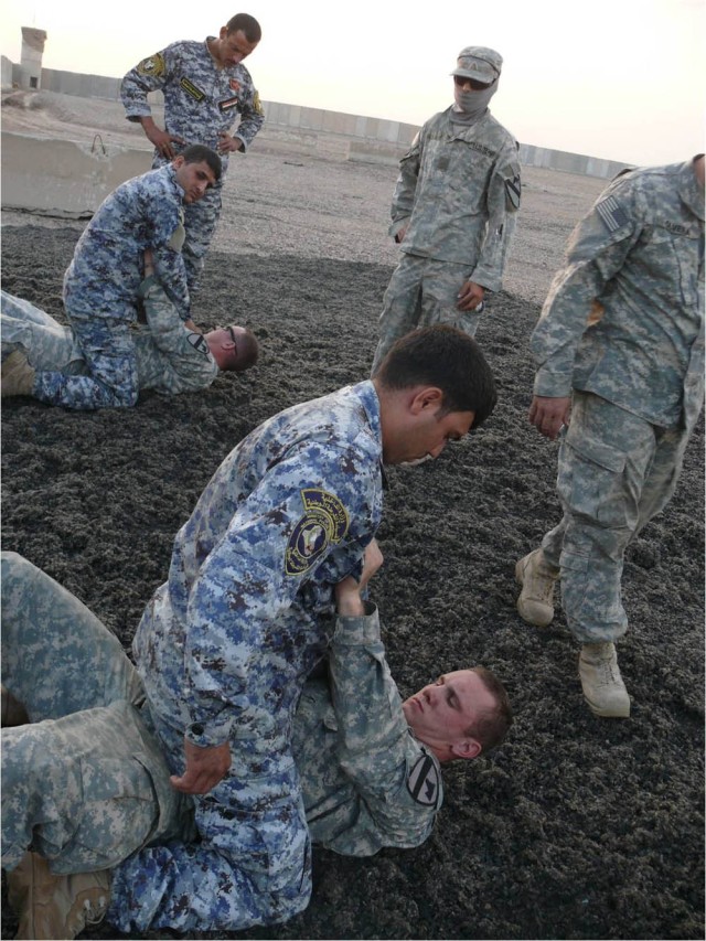 BAGHDAD - Pittsburg, Penn. native Spc. Nathan Lohr (on the ground), a cavalry scout from 1st Brigade Combat Team, 1st Cavalry Division, practices a straight-arm bar submission hold with an Iraqi Federal Policeman during a non-lethal force class held ...