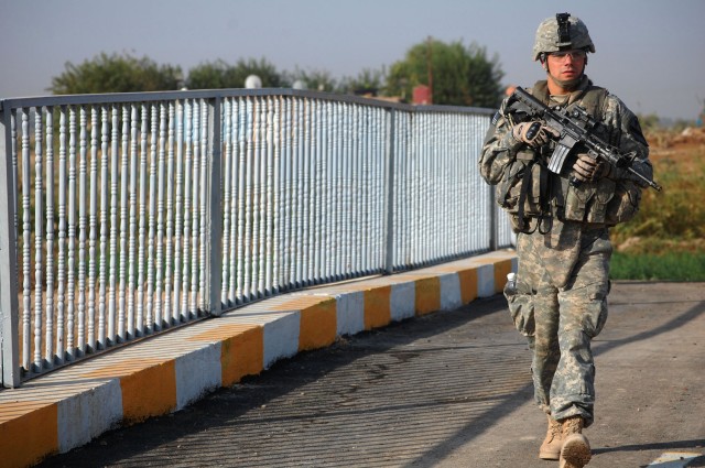 TAJI, Iraq - Evansville, Ind. native, Pfc. Travis Conder, an armor crewman attached to the 1st Brigade Combat Team, 1st Cavalry Division, walks across the Sheik Abdullah Bridge during a final inspection in Taji, Nov. 10. The bridge offers a faster...