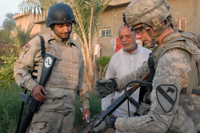 BAGHDAD-Holly Hill, S.C. native, Staff Sgt. Gerald Bush (right), a squad leader with 1st Battalion, 5th Cavalry Regiment, clears an AK-47 found at a house in Tarmiyah, on the northeastern edge of Baghdad, during a combined cordon and knock conducted ...