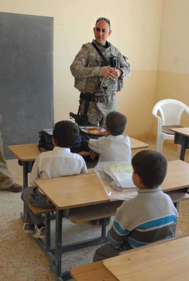 Sergeant first Class Raymond Loriaux, a team leader with the 414th Civil Affairs Company, talks to children in the school in the small village of Sarbir in Kirkuk province, Iraq, Nov. 12. Loriaux's civil affairs team helped to organize a school suppl...