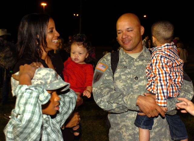 Staff Sgt. Justin Casson, from 3rd Battalion, 8th Cavalry Regiment, 3rd Heavy Brigade Combat Team, 1st Cavalry Division, holds his 4-year-old son, Micah, as he is reunited with his Family in the evening hours of Nov. 10 at Cooper Field on Fort...