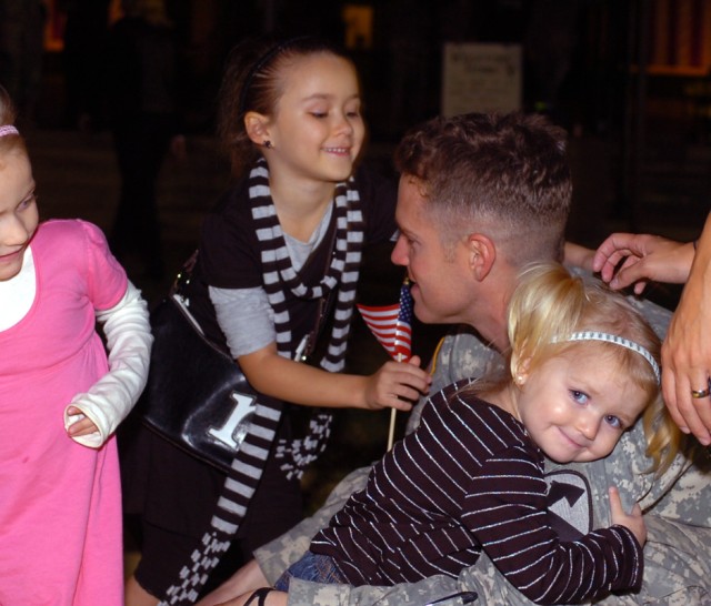 Staff Sgt. Roman Rozell, of 3rd Battalion, 8th Cavalry Regiment, 3rd Heavy Brigade Combat Team, 1st Cavalry Division, bends down as his 2-year-old daughter Rylan, hugs him and smiles as his other two daughters, 4-year-old Jaisalyn and 7-year-old...
