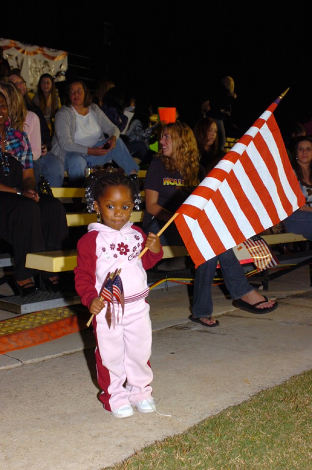 Two-year-old Takara Guice, holds one large American flag and two smaller American Flags as she waits for her father, Staff Sgt. Truman Guice, of 3rd Battalion, 8th Cavalry Regiment, 3rd Heavy Brigade Combat Team, 1st Cavalry Division, Nov. 10, at...