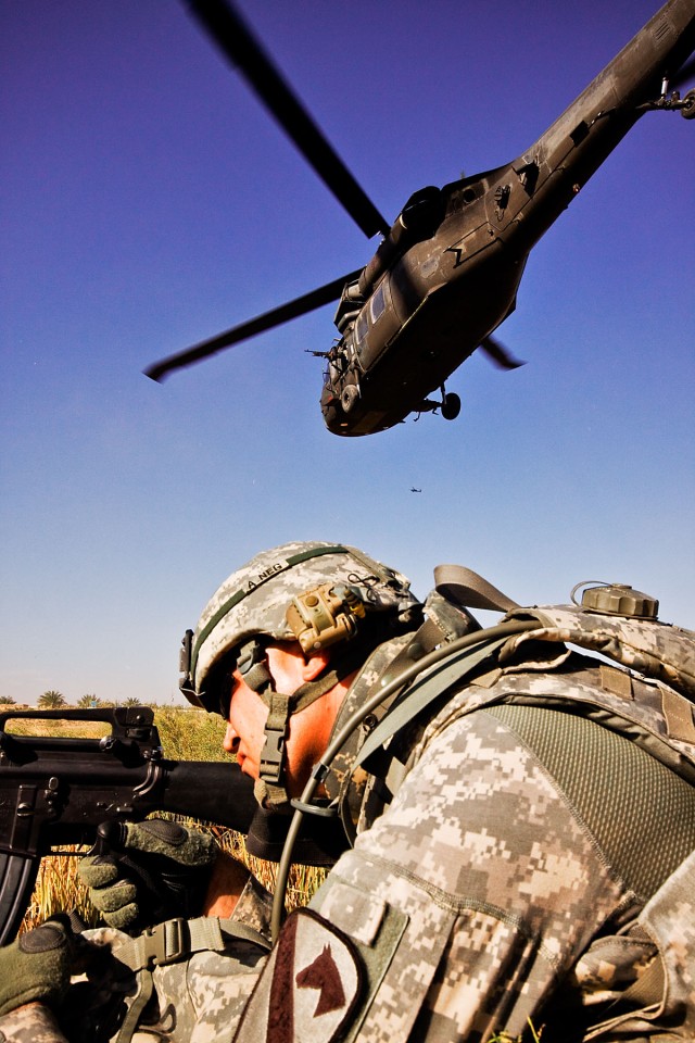TAJI, Iraq-After air assaulting into a landing zone, Spc. Khalid Hermez, from Detroit, pulls security as a UH-60 Black Hawk helicopter departs the landing zone. U.S. Soldiers from the 1st Air Cavalry Brigade and the 34th Iraqi Army Brigade...