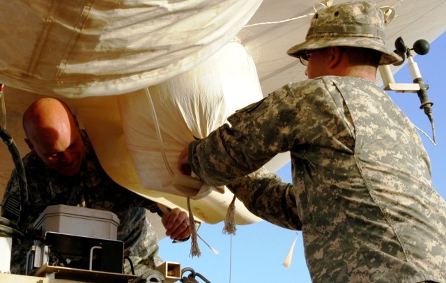 CONTINGENCY OPERATING LOCATION Q-WEST, Iraq - Staff Sgt. John W. Pidgette (left), noncommissioned officer-in-charge and native of Horn Lake, Miss., and Andrew N. Faulkner, a camera technician from Hernando, Miss., seal the ballonet access port of...