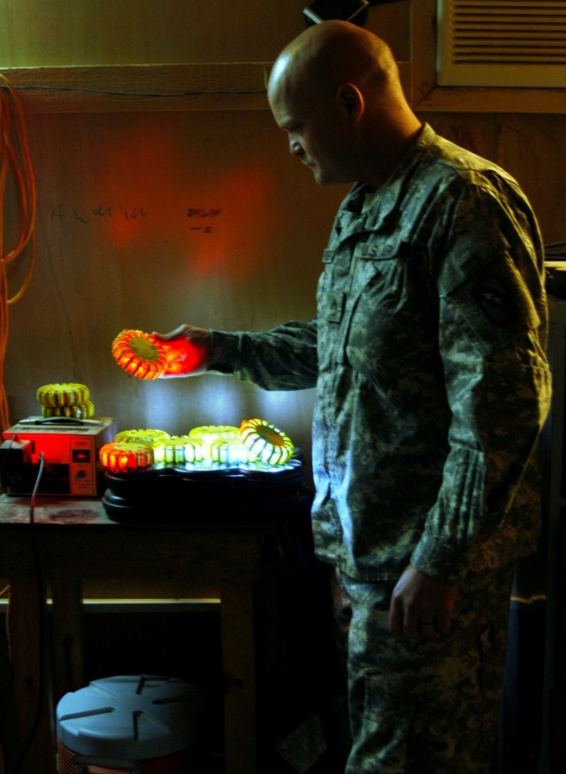 CONTINGENCY OPERATING LOCATION Q-WEST, Iraq - Staff Sgt. John W. Pidgette (left), noncommissioned officer-in-charge and native of Horn Lake, Miss., examines an array of signal lights used on Q-West's 17-meter Aerostat during an inspection Nov. 7....