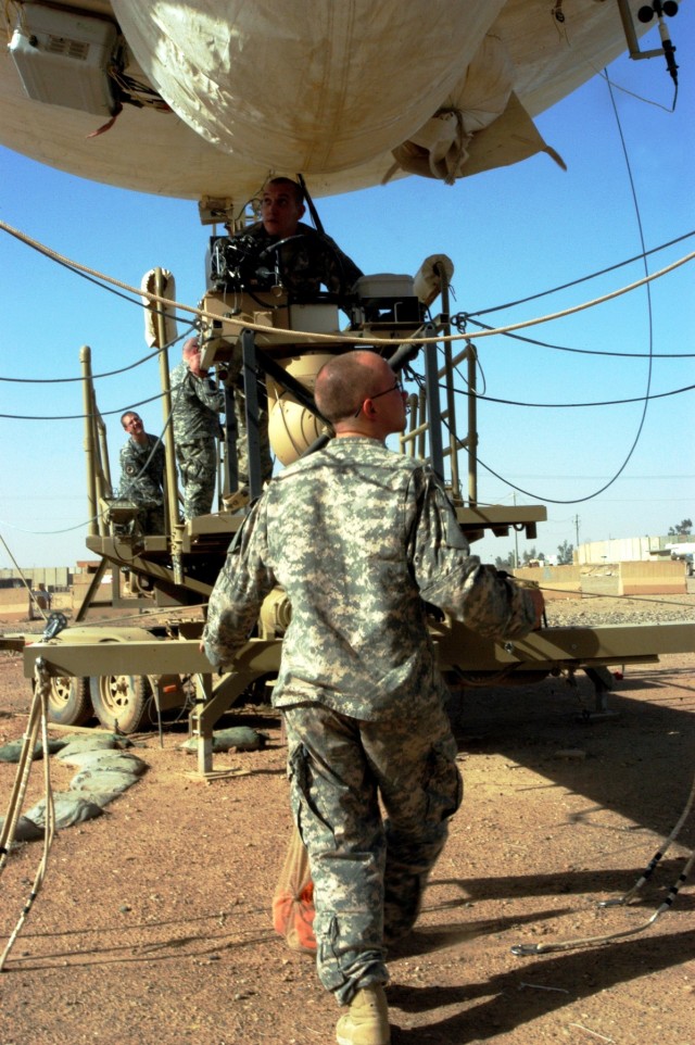 CONTINGENCY OPERATING LOCATION Q-WEST, Iraq - Crewmembers of Bravo Team take up their duty positions around the mobile mooring station of Q-West's 17-meter Aerostat during a hoisting operation Nov. 6. The aerostat crewmembers - all from A Company,...